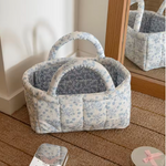 Quilted home storage basket with a handle and decorative flower design.