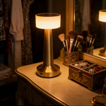 Gold bedside table lamp casting a warm white glow in a cozy bedroom.