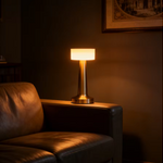Portable cordless gold LED lamp adding ambient lighting to a dining table.