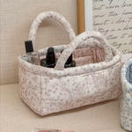 Small quilted floral storage basket with a handle for home organization.